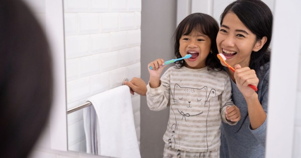 鏡の前で一緒に歯を磨く母と子の笑顔