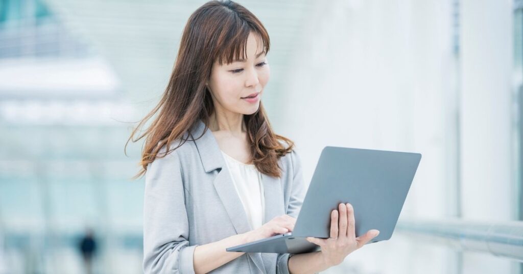 ノートパソコンを見つめる女性(引き寄せを実践しようとする現代的な人物像)