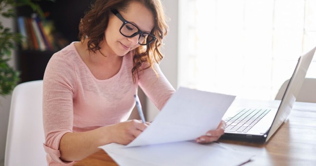 書類を見ながらメモを取る女性|自分を守る行動をとるイメージ