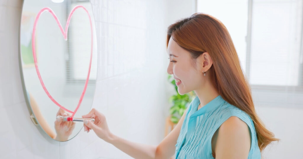 理想の人と出会った後に大切な心構えを表現した、ハートを描く女性の笑顔の写真