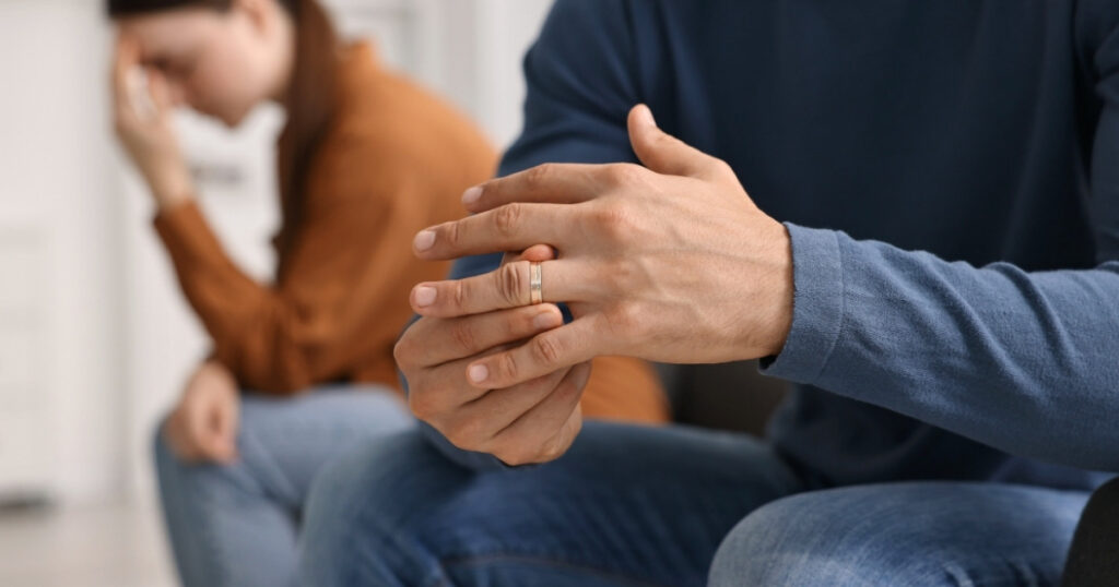 離婚危機にある夫婦と結婚指輪に手を添える男性