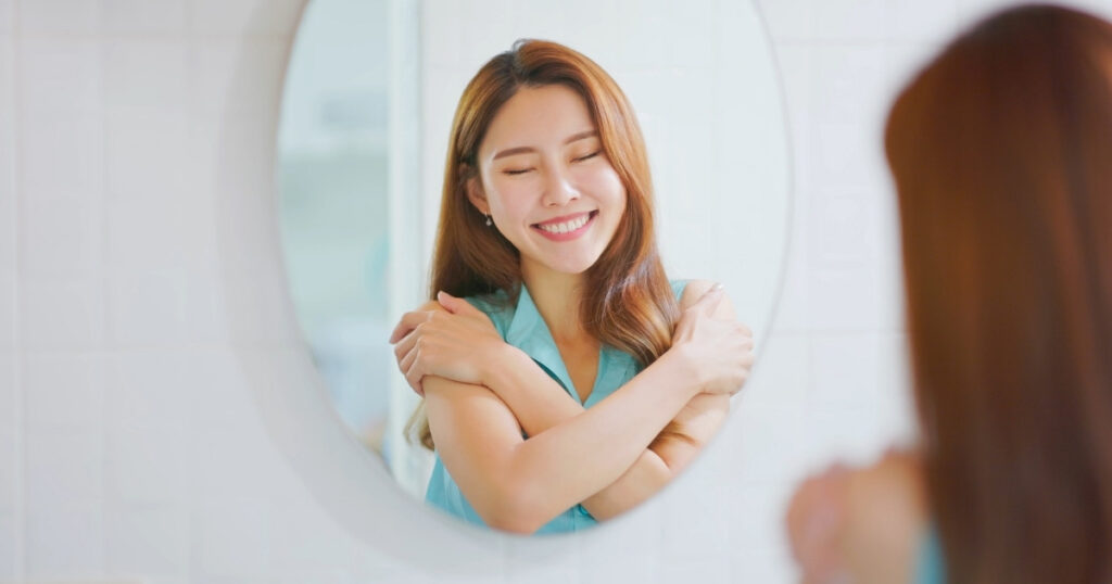 に映る自分を愛おしそうに見つめる女性。自己愛と意識が恋愛運を変える象徴