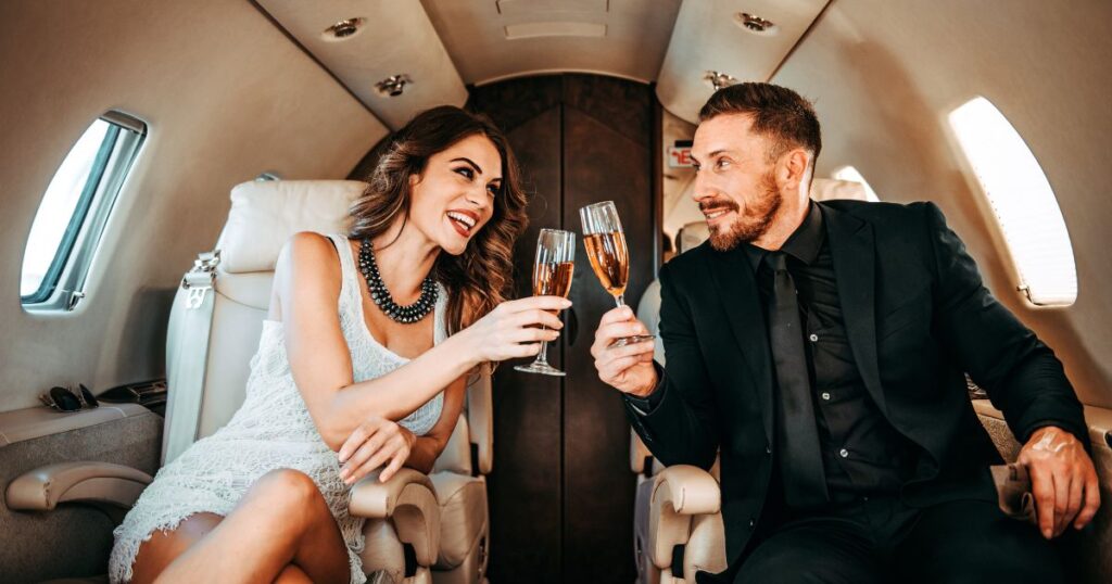 プライベートジェット内で乾杯する男女の笑顔|引き寄せの法則で夢を叶えた有名人の成功体験を表現