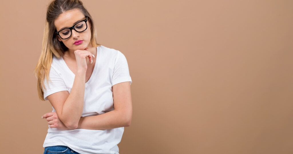 不安げに考え込む女性。モテを妨げるNG習慣や思考を象徴