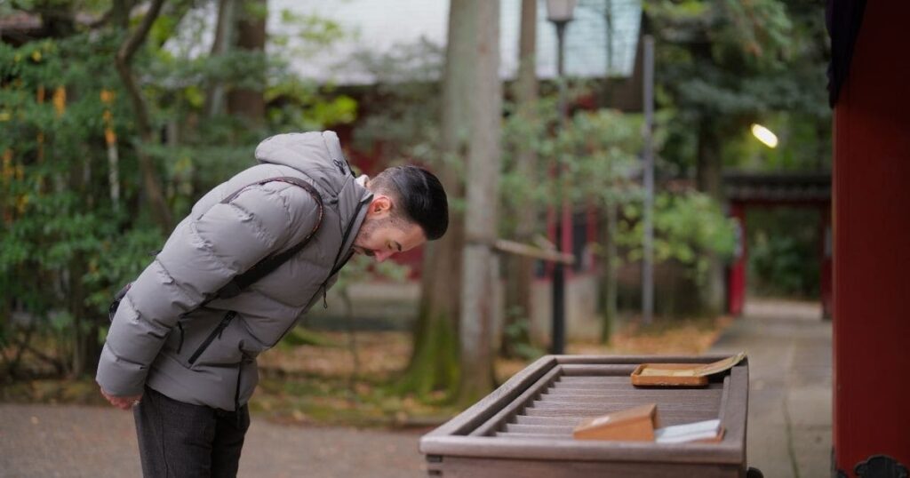 金運UPのために神社で参拝マナーを実践する男性