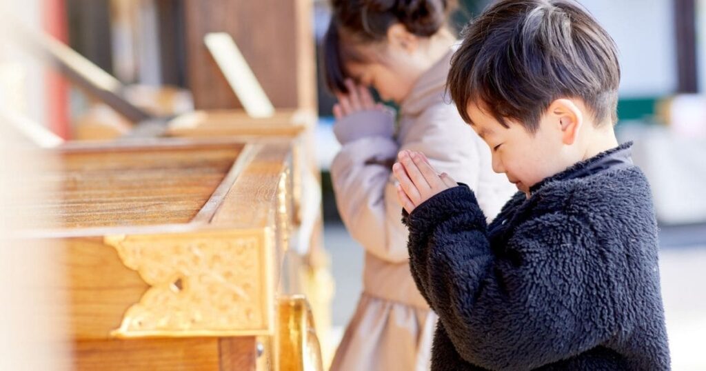 静かに祈る子供の姿で、正しい参拝マナーと開運日を想起させる画像