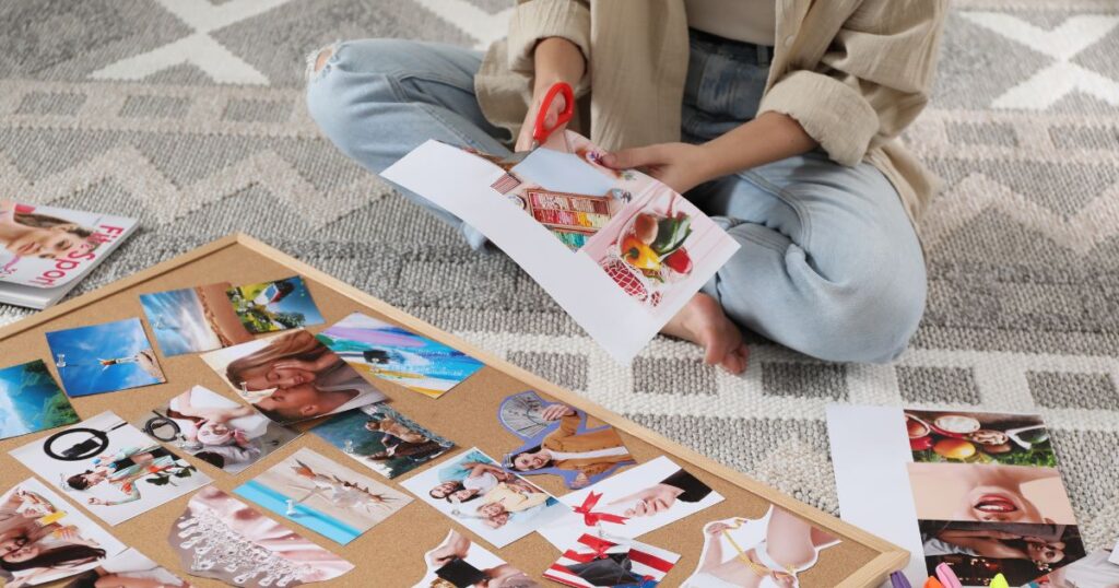 床に広げた写真や雑誌を使って、ビジョンボードを丁寧に作成する女性の様子