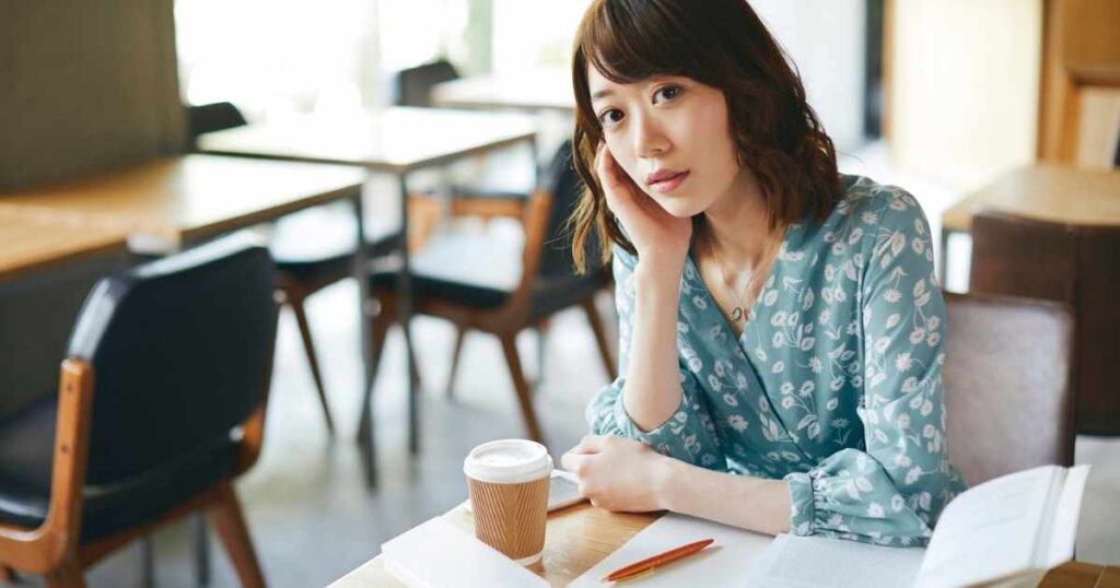 カフェでリラックスした様子の女性。金運を引き寄せる行動習慣を想起させる画像